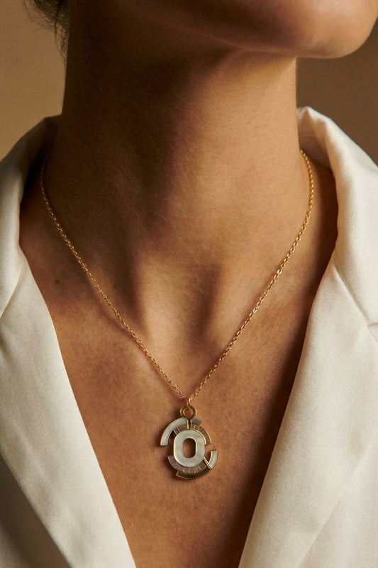 Necklace with a pendant worn by a person against a neutral background