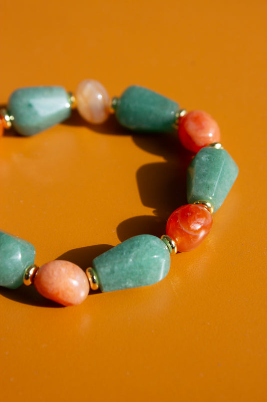 Bracelet with green aventurine and orange carnelian beads on an orange background