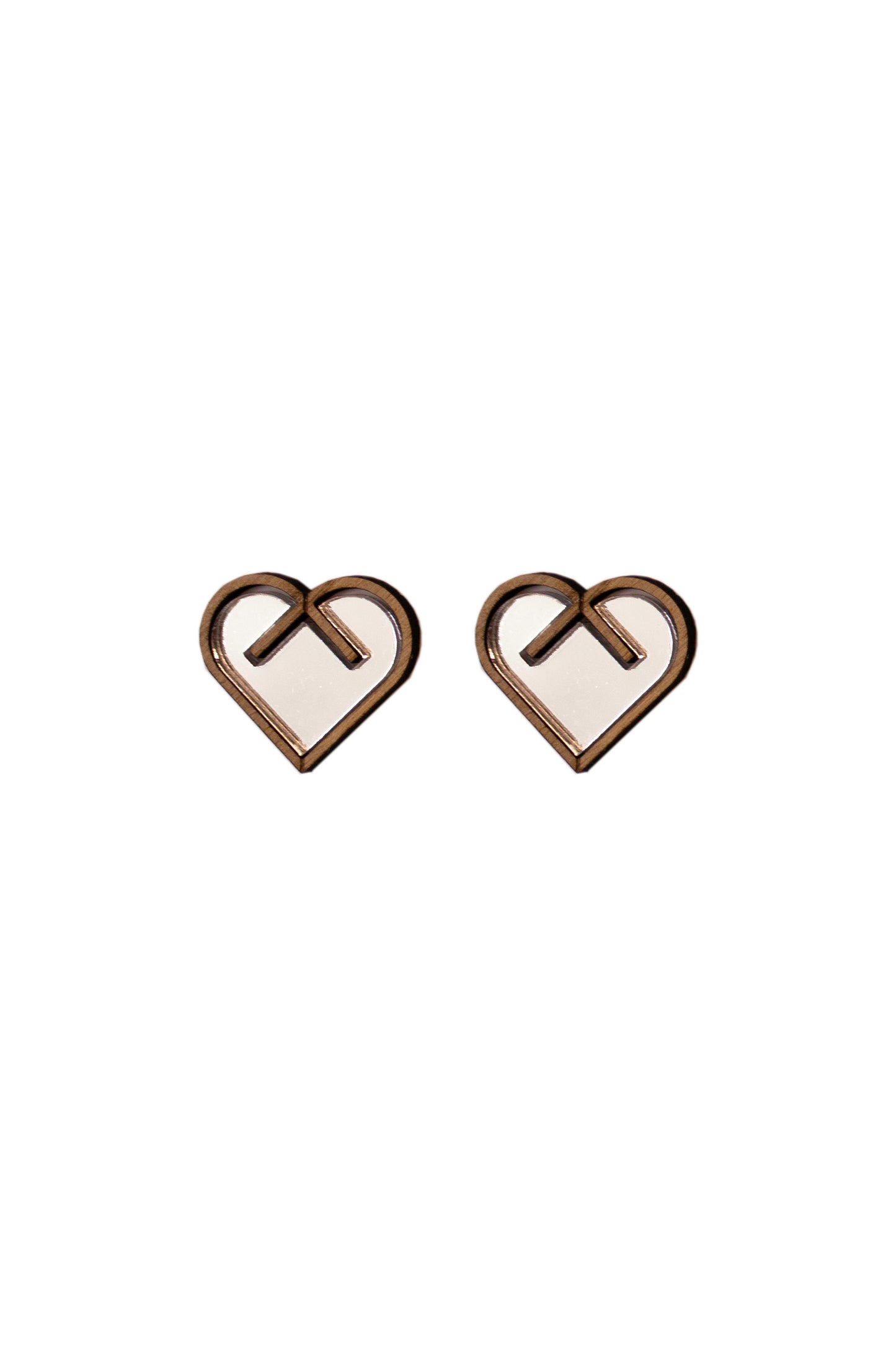 Heart-shaped earrings with a central silver inlay on a white background. Laser cut earrings made from plywood, acrylic and walnut wood.