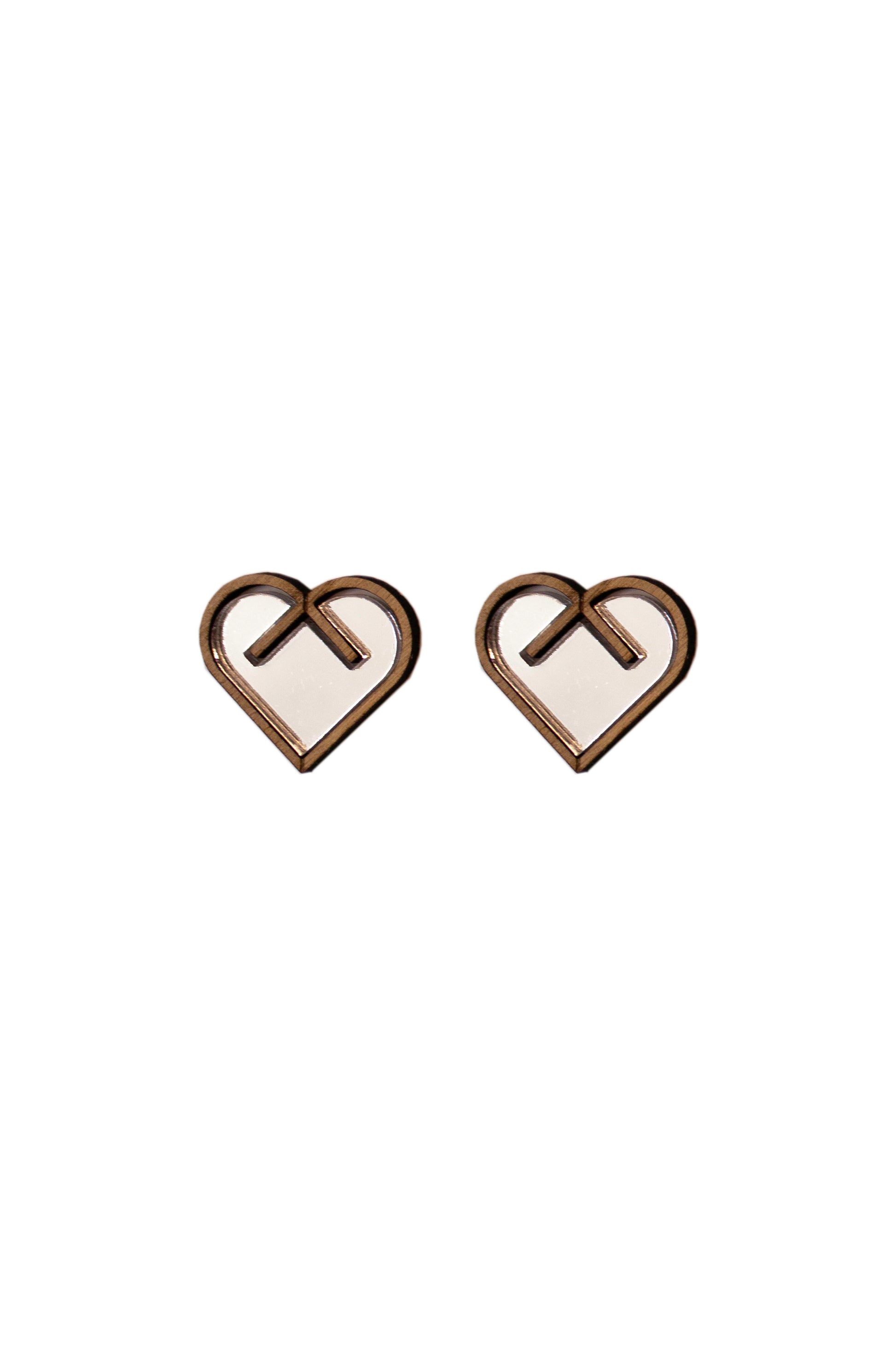 Heart-shaped earrings with a central silver inlay on a white background. Laser cut earrings made from plywood, acrylic and walnut wood.