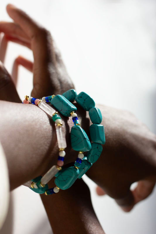 Turquoise beaded bracelet on a wrist with a blurred background