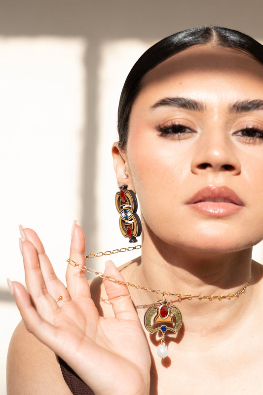 Woman wearing Egyptian inspired jewellery with a neutral background