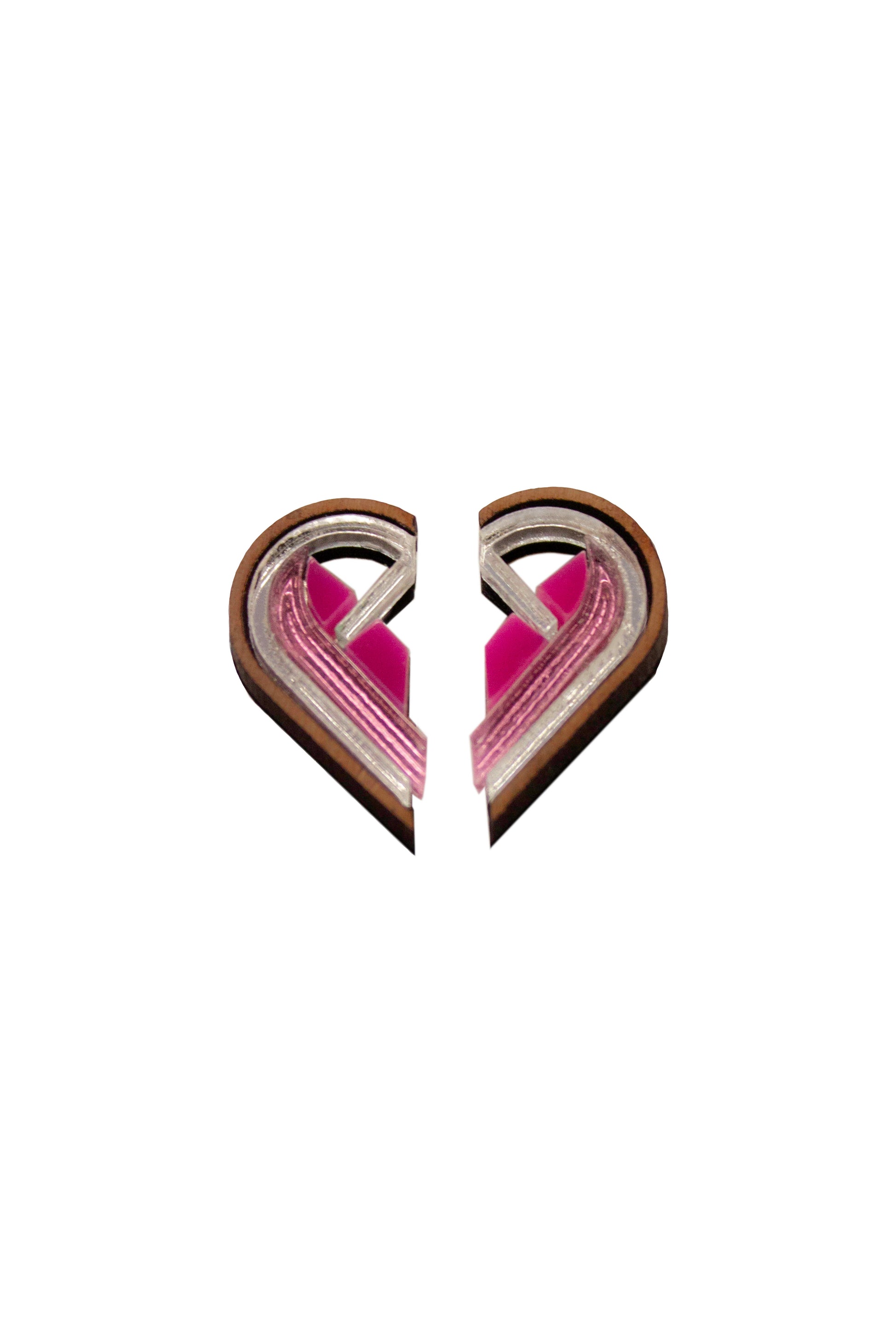 Two semi heart-shaped objects with pink interior and silver border on a white background. Laser cut earrings made from acrylic, plywood and walnut 
