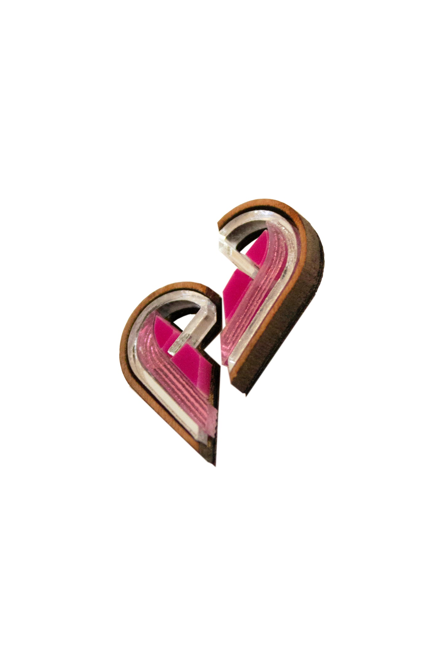 Pair of pink and silver semi heart shaped earrings on a white background. Laser cut earrings made from acrylic, walnut wood and plywood 