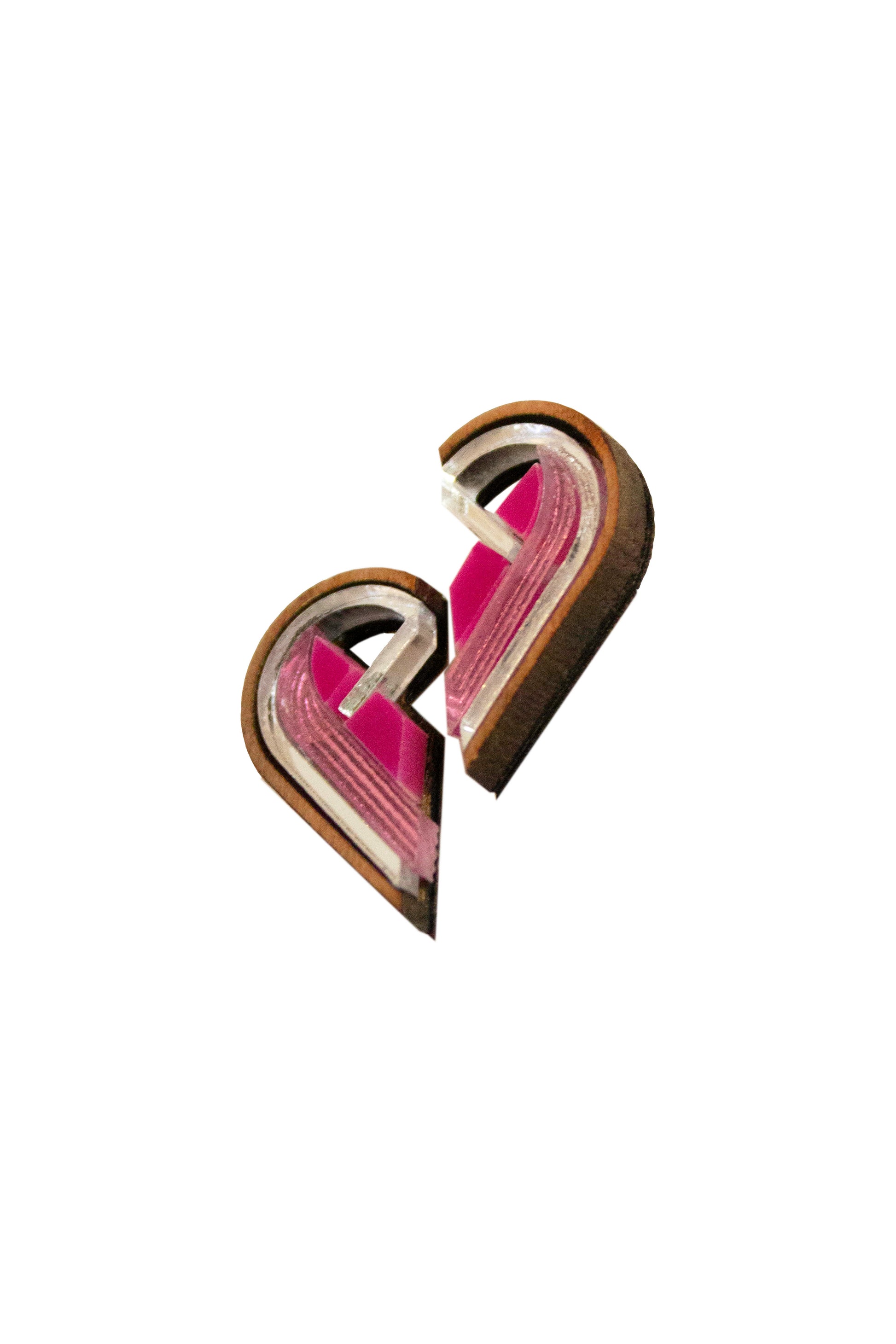 Pair of pink and silver semi heart shaped earrings on a white background. Laser cut earrings made from acrylic, walnut wood and plywood 