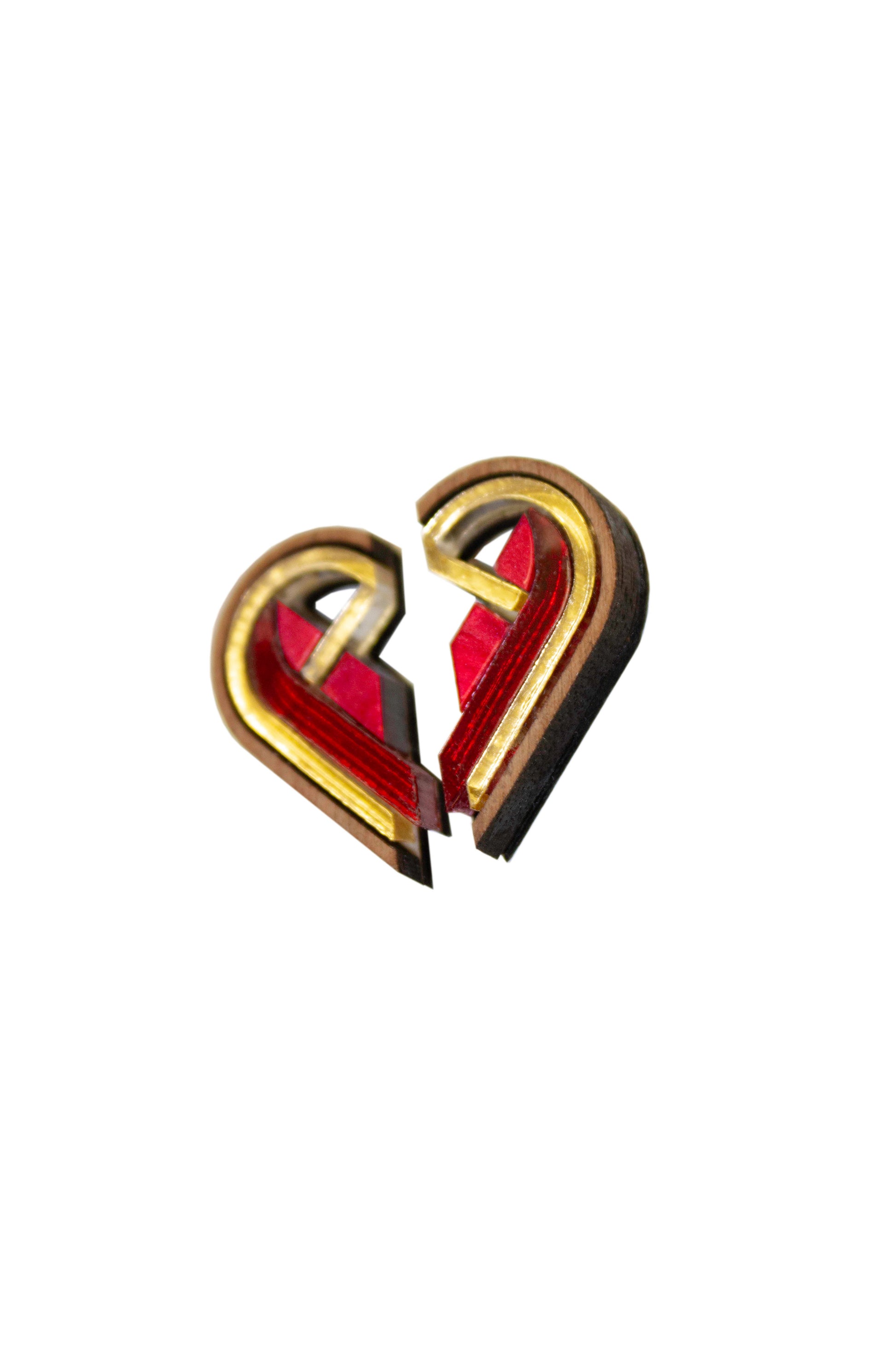 Two half heart-shaped earrings in red and gold on a white background. Lasercut earrings made from acrylic plywood and walnut wood 