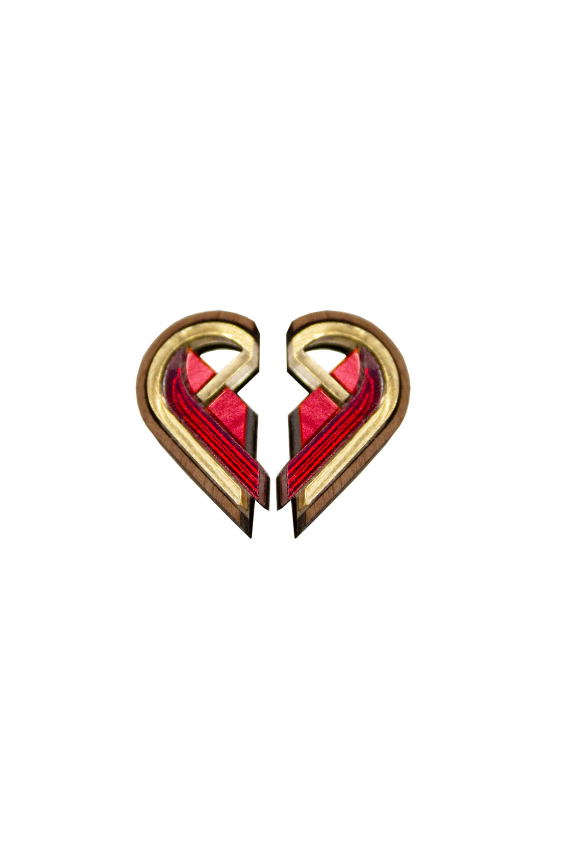Two half-heart shaped earrings with red and gold accents joined together on a white background. Laser Cut earrings made from walnut wood, plywood and acrylic 