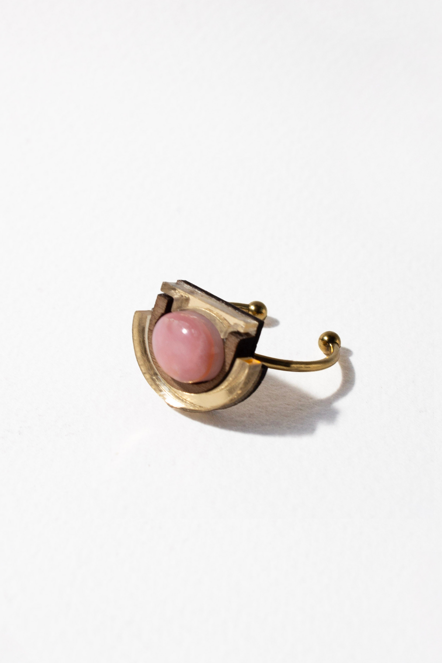 Gold ring with a pink stone on a white background