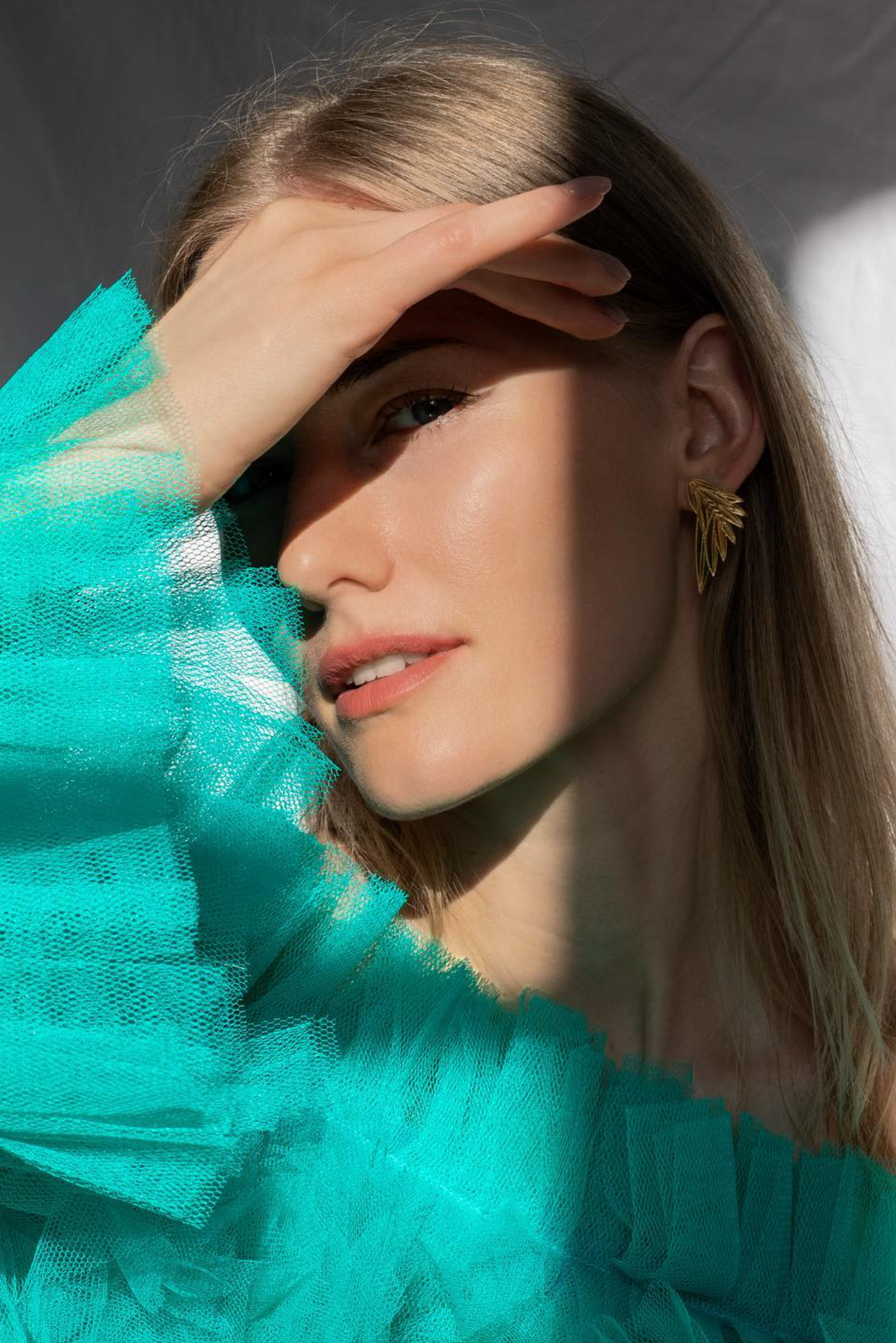 Woman wearing gold acrylic laser cut angel wing earrings