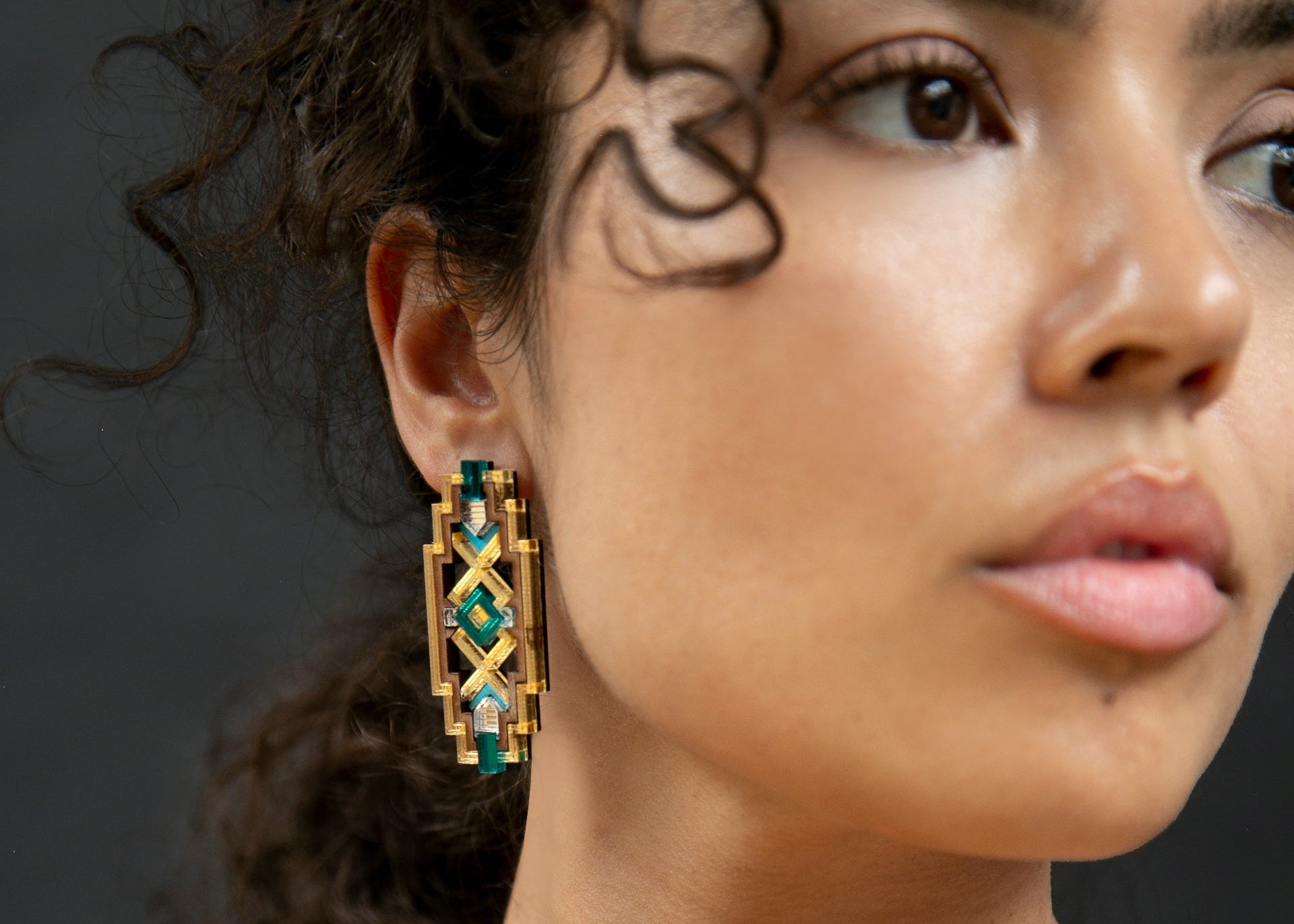 Zulia Earring model wearing walnut wood, lasercut, geometric, teal gold and mint green earrings